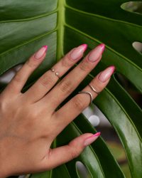 woman-showing-her-nail-art-fingernails-against-monster-leaf